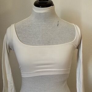 Very cropped for girls with bigger boobs. White long sleeve. Stretchy